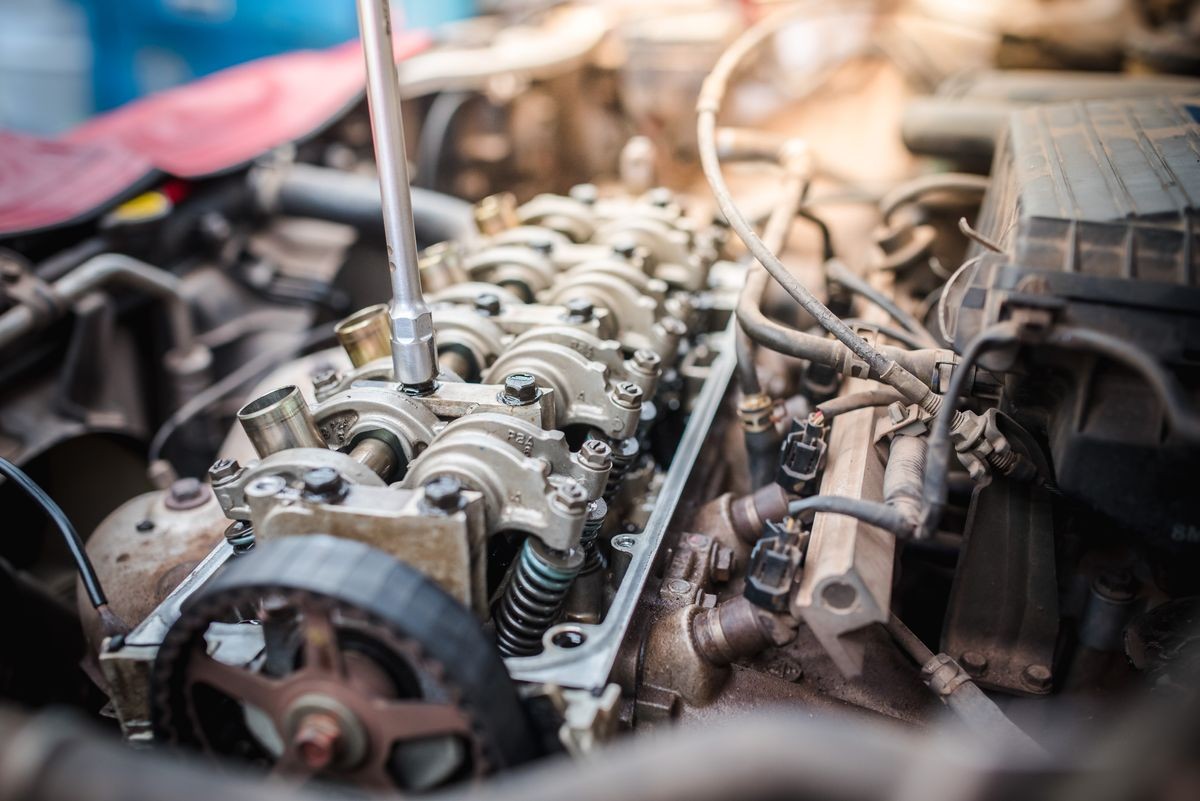 Mechanic hands tighten nut with wrench while repairing engine